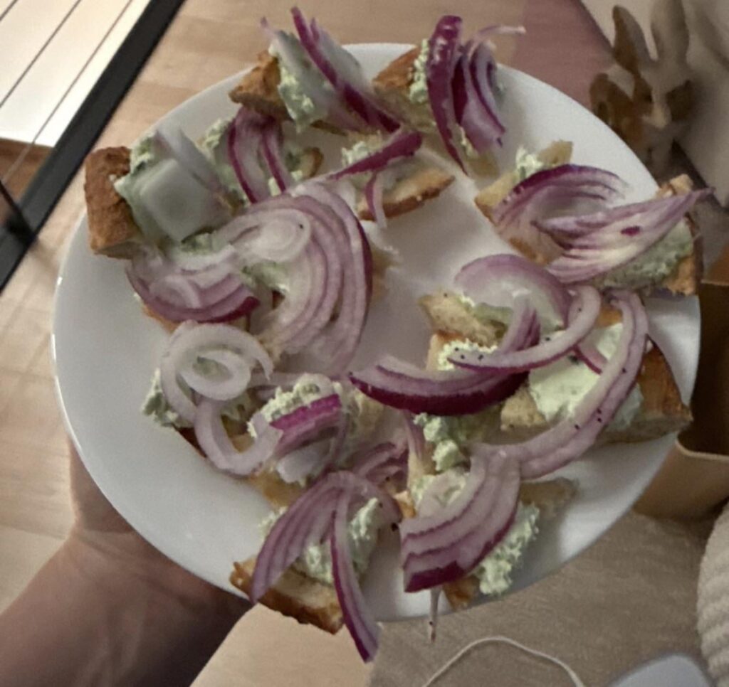 Onion bagel with scallion cream cheese and a little bit of red onion