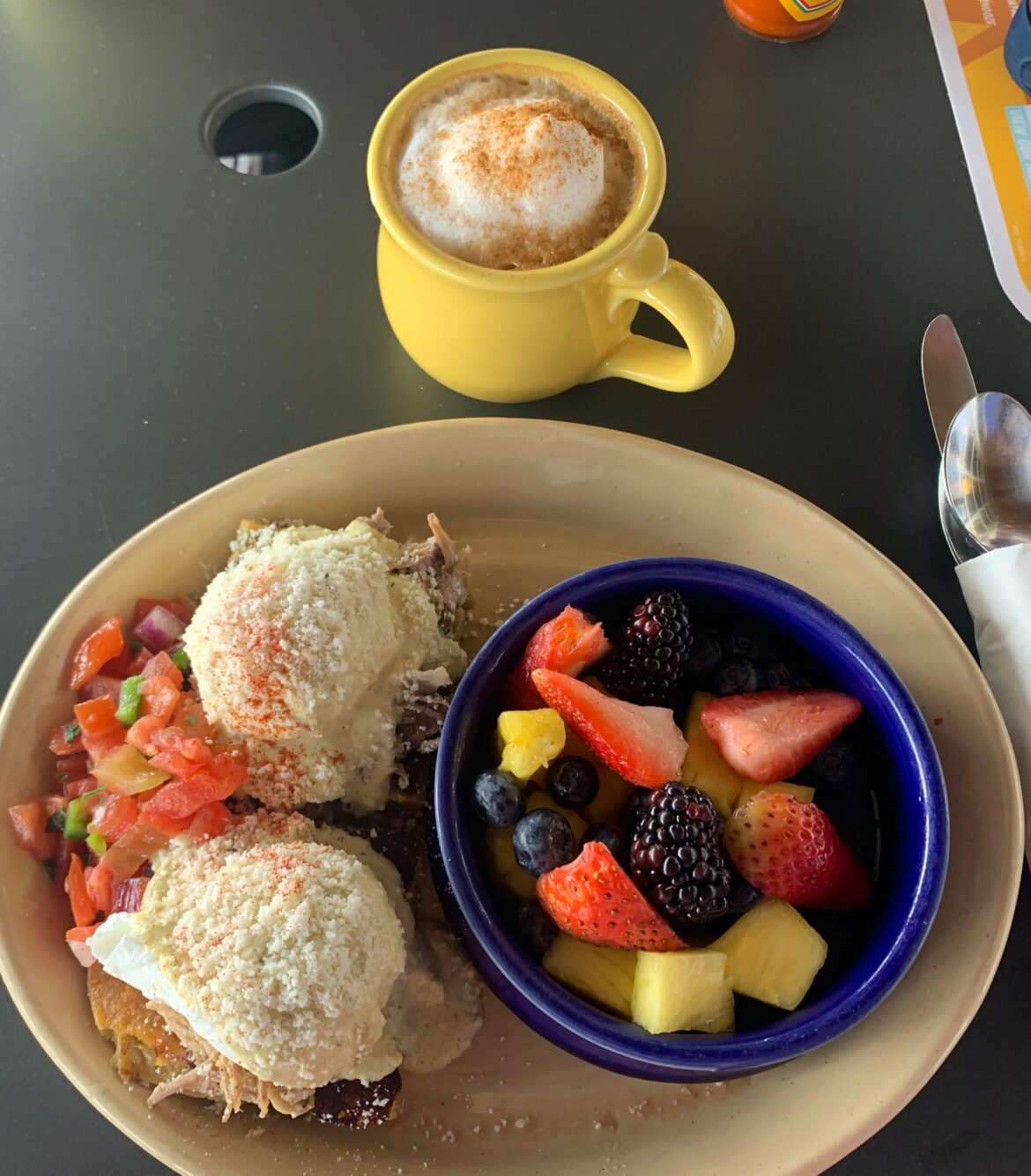 Eggs Benedict ranchero style with a side of mixed fruit 🥰