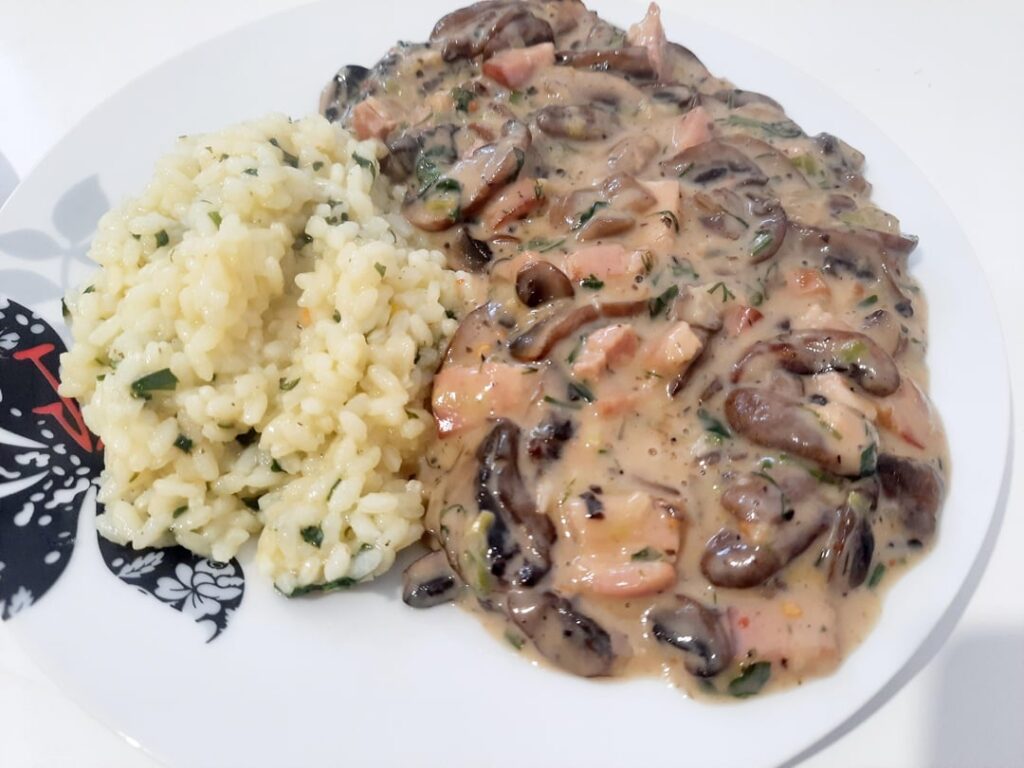 Brown Champignon mushrooms stew (ciulama) with bacon & rice with parsley