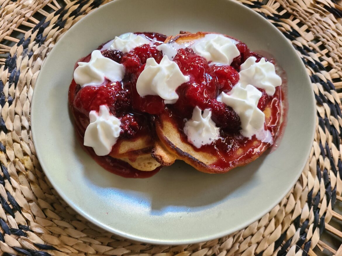 Pancakes with berry syrup and whipped cream