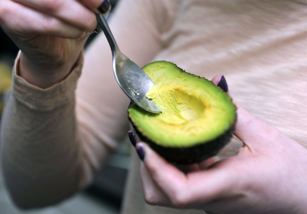 Woman eating an avocado