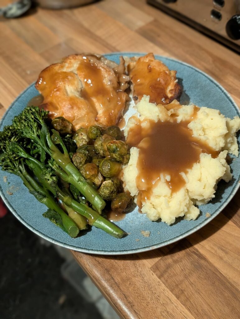 Homemade chicken and mushroom pie, mash and greens