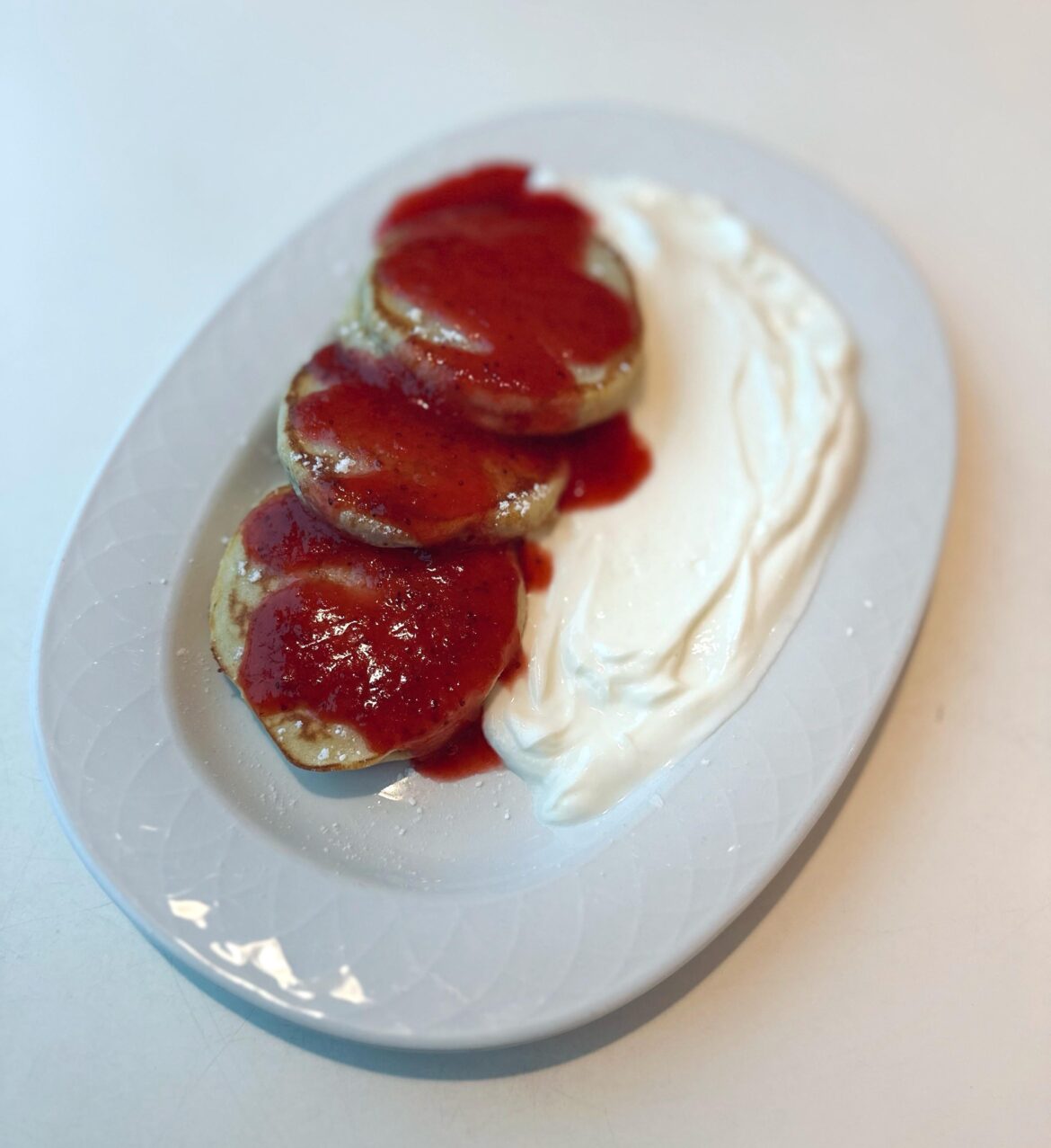 Warm pancakes served with strawberry jam and vanilla quark cream
