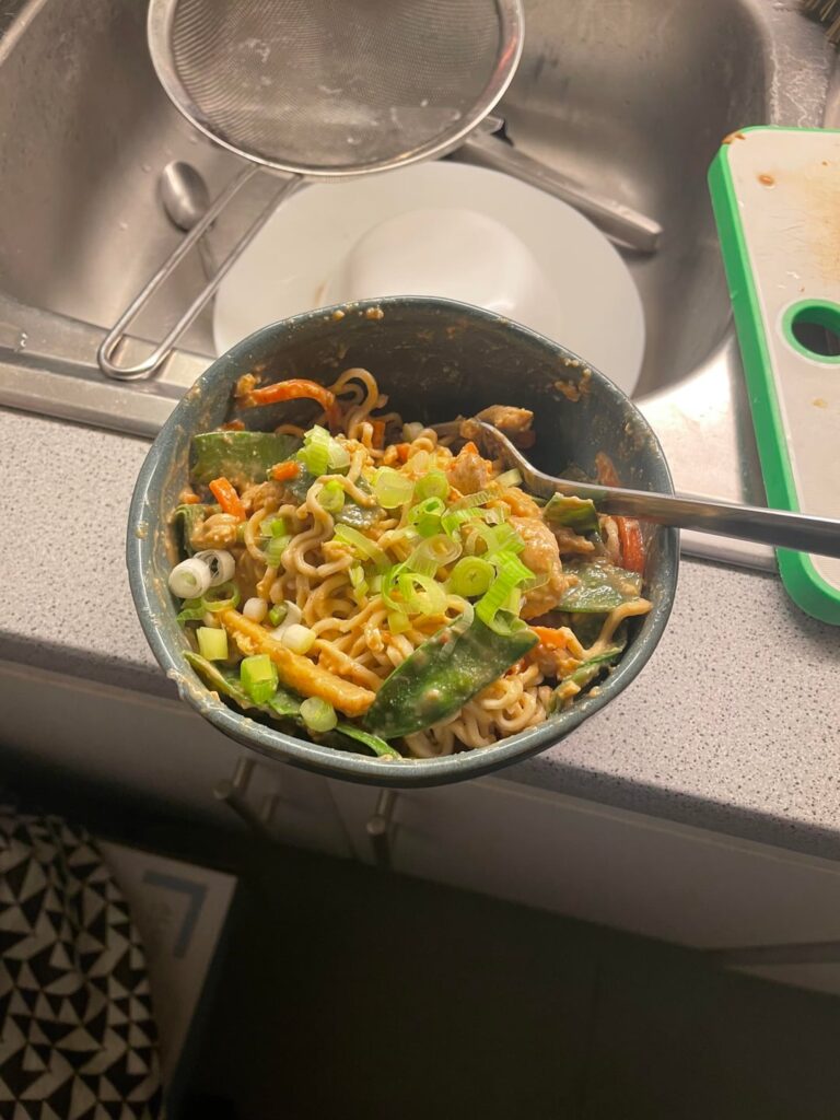 Making noodles with chicken and vegetables and a lot of peanut sauce