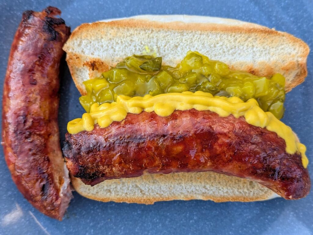 Grilled Farmer's sausage served plain & hotdog style w/ a toasted bun, mustard & tangy relish
