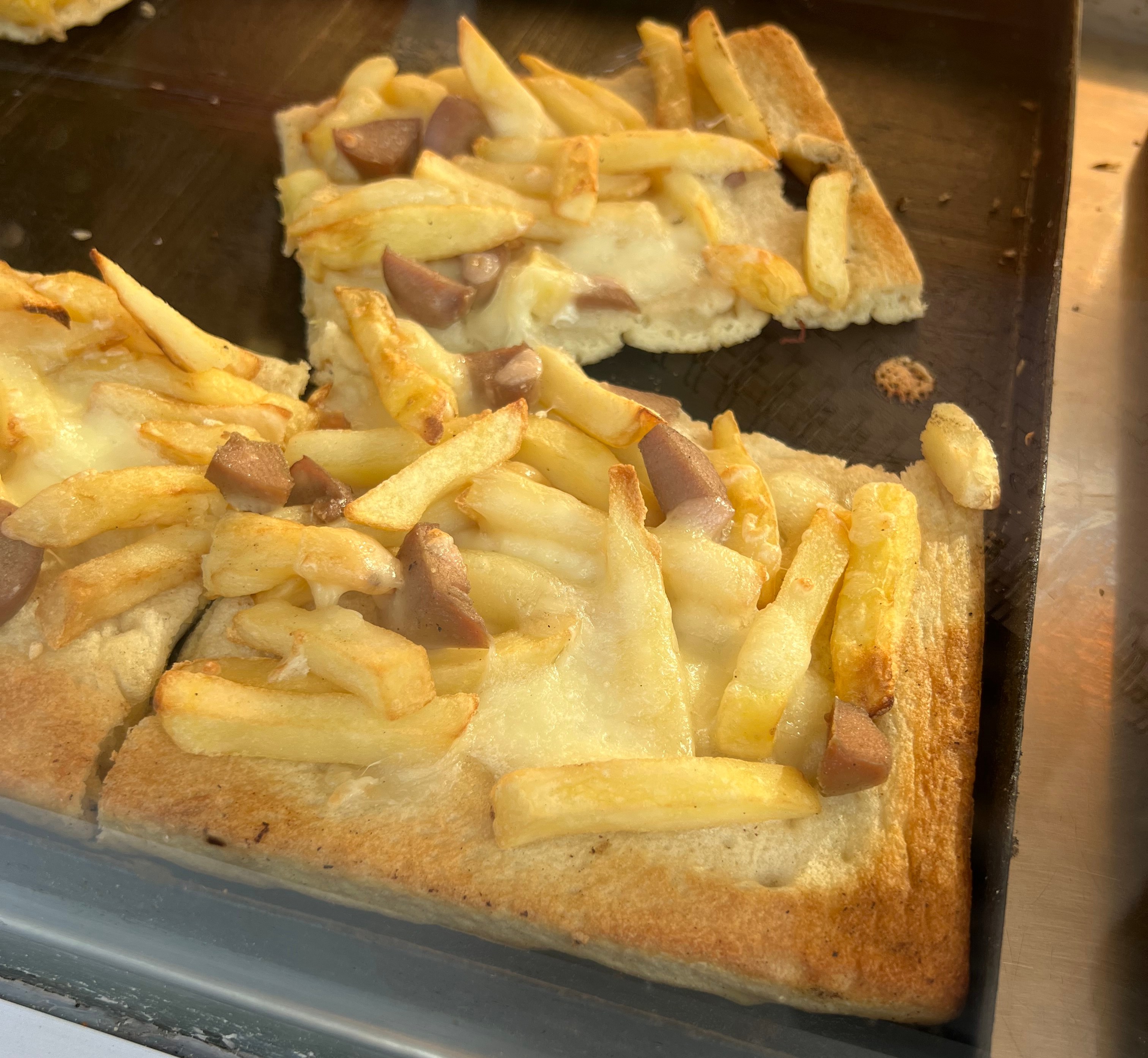 Pizza with french fries and sausage.