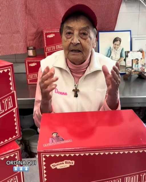 Silvana Bini promoting her Tuscan recipes packaged in red boxes.