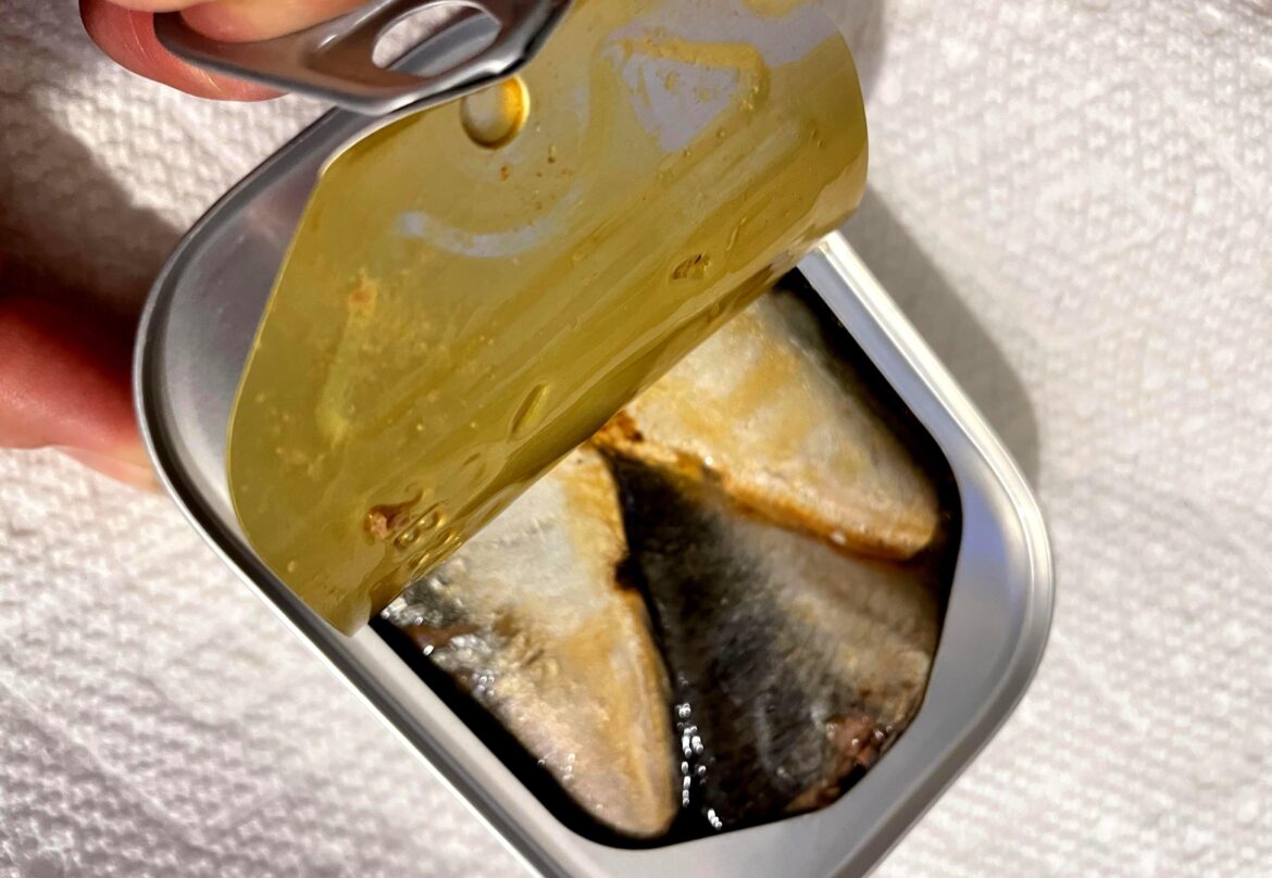 We need a word for the specific anxiety you feel when peeling back the lid, hoping you dont get flicked with fishy oil