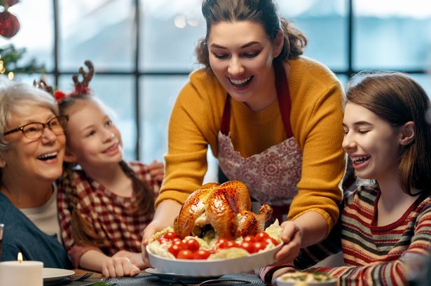 Happy family are having dinner at home. Celebration holiday and togetherness near tree.