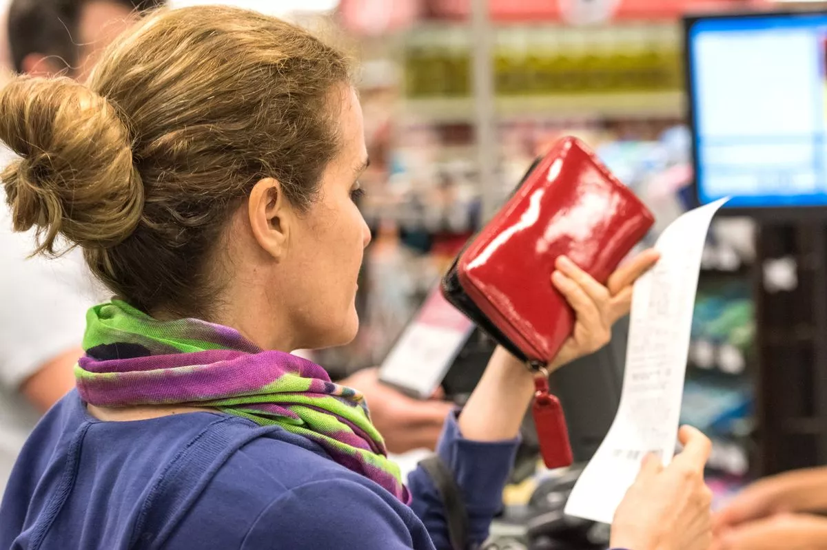 Mature woman checking the bill when paying at a supermarket