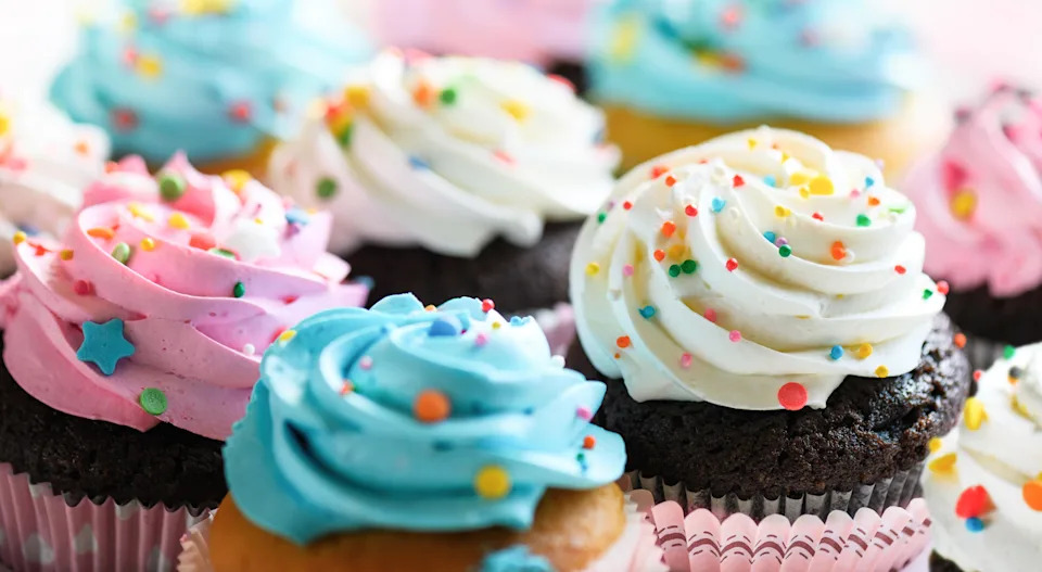 Assorted cupcakes with swirled frosting and colorful sprinkles on top