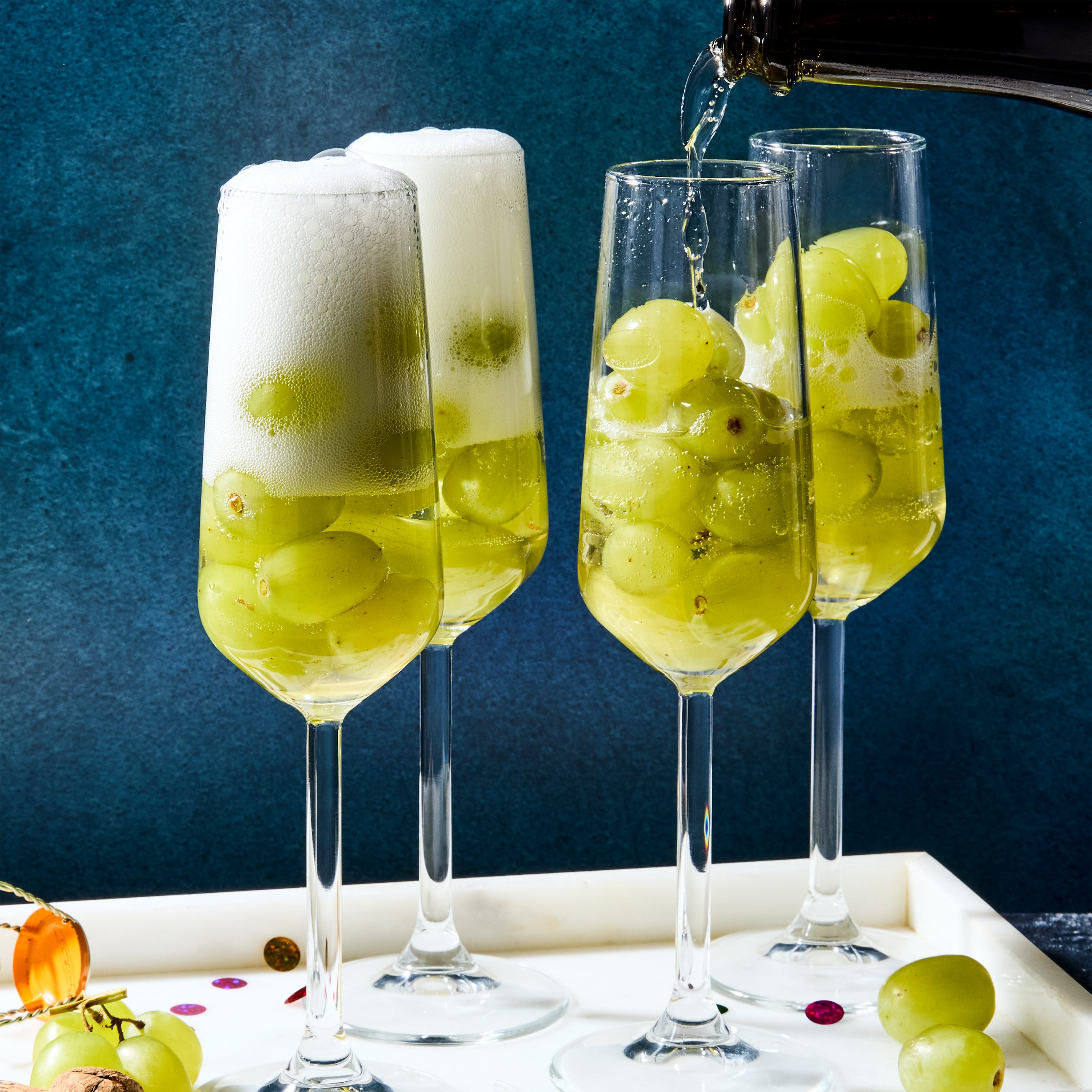 glasses of champagne filled with 12 green grapes