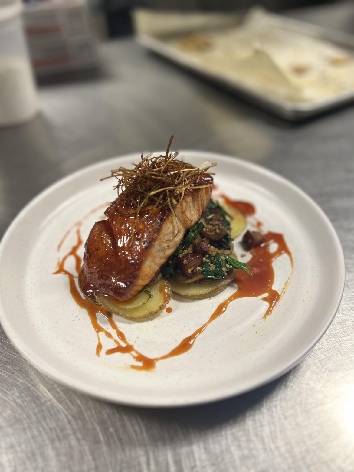 Gochujang honey glazed salmon, fried leek haystack, spinach with cremini pancetta millet, sliced Yukons
