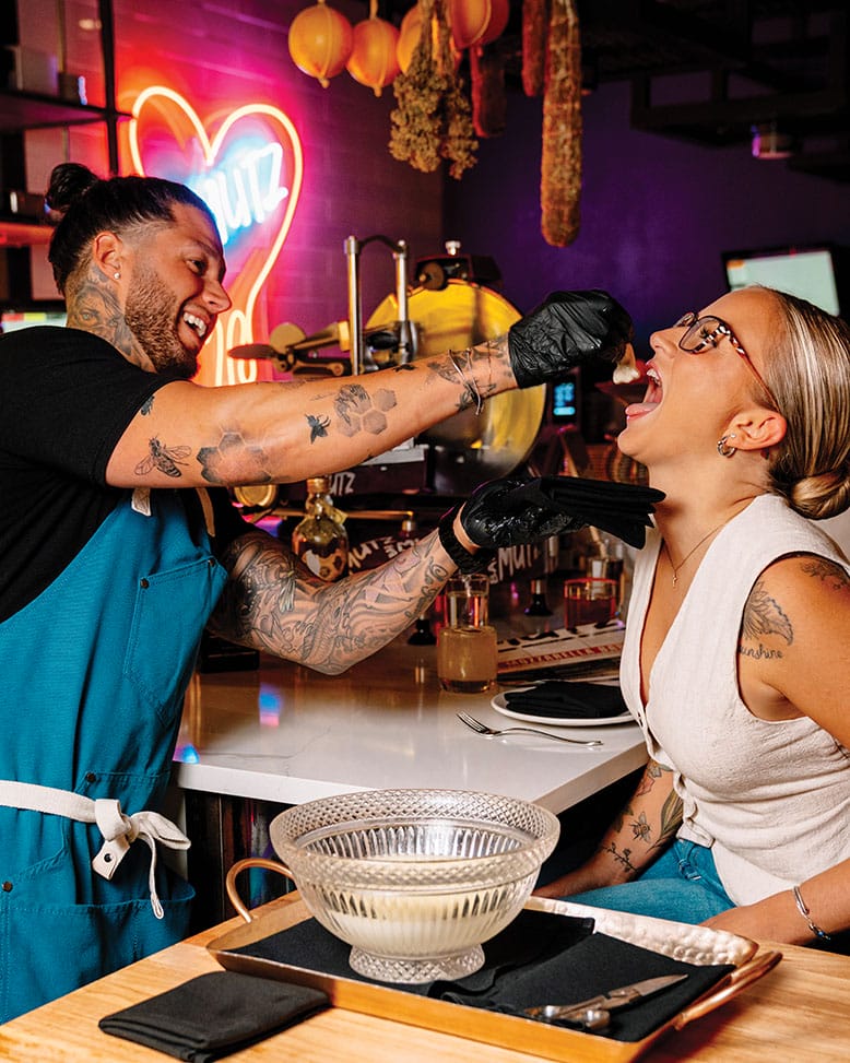 At Bar Mutz in Westwood, chef Robbie Felice feeds a customer fresh mozzarella, much to her delight; creamy lobster macaroni.