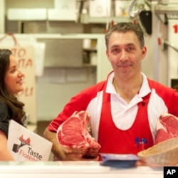 Third-generation Florentine butcher Luca Menoni, with Antoinette Mazzaglia, explains to tourists how he selects the meats for which the city is famous.