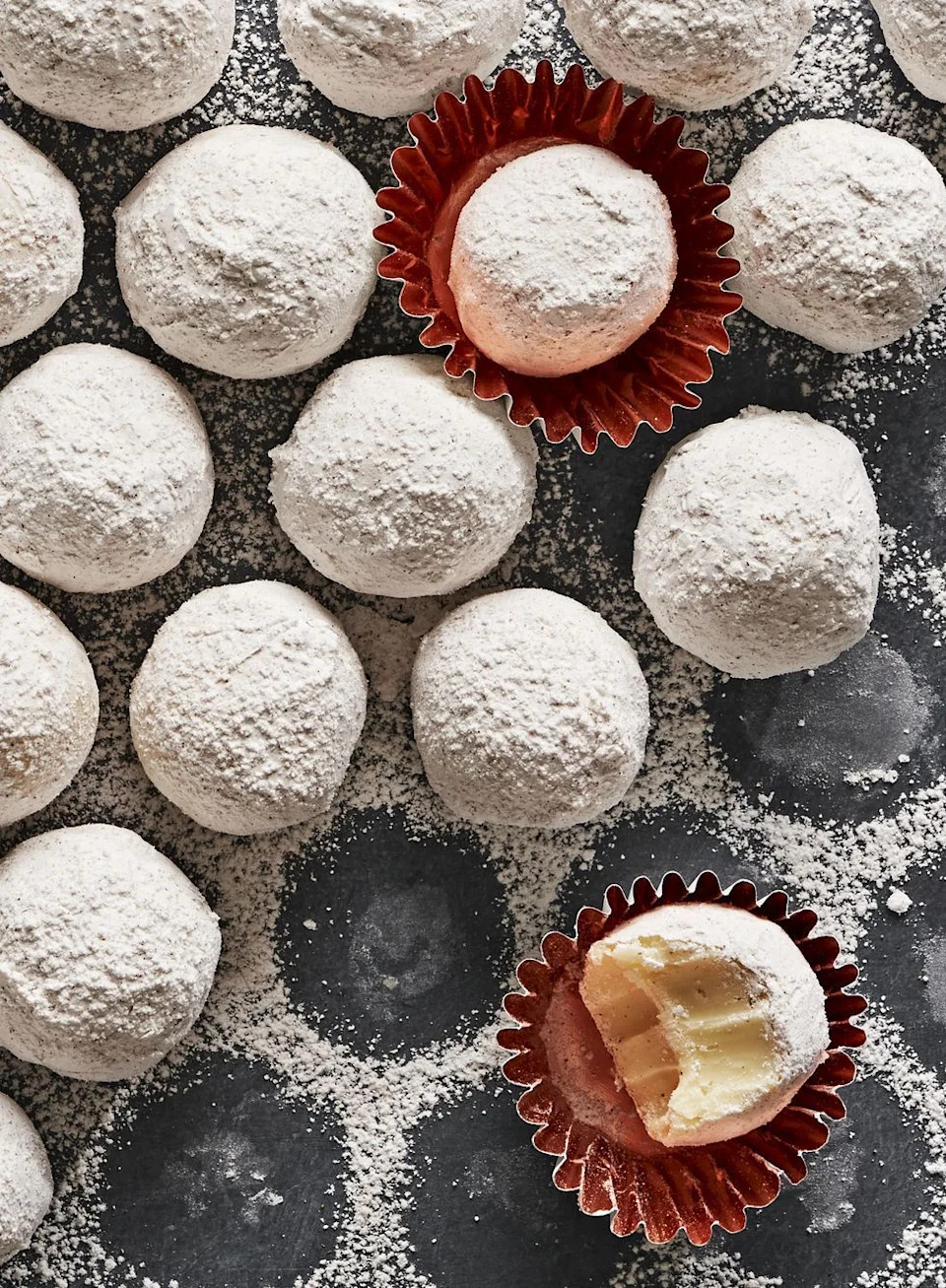 eggnog truffles covered in powdered sugar on a grey slate background