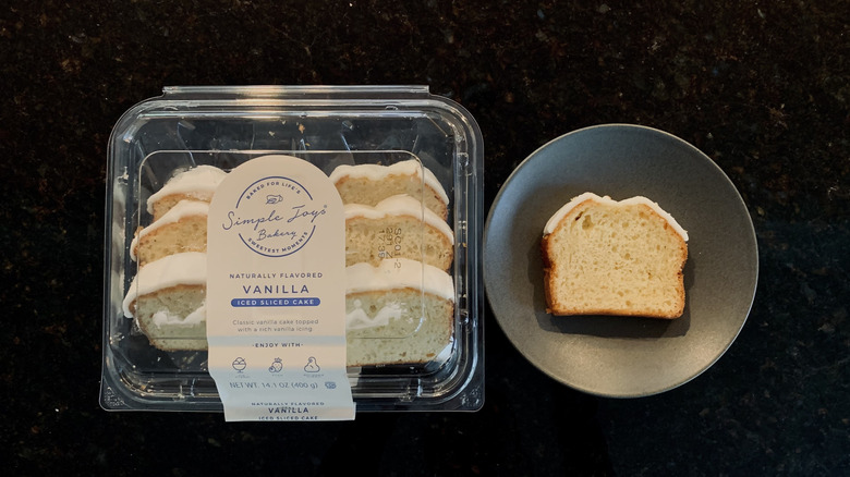 Simple Joys Vanilla Iced Cake slice on a plate next to package