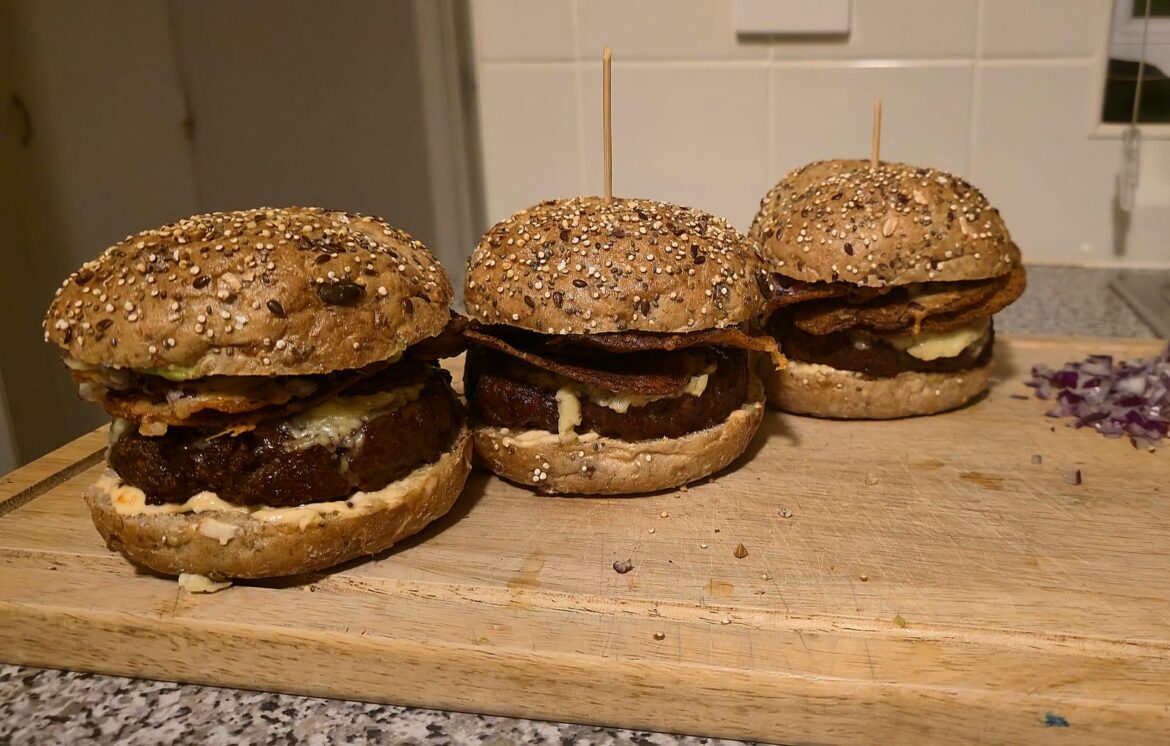 Taco burger with salsa tortilla chips onions and cheese jalapeño mayo and guacamole