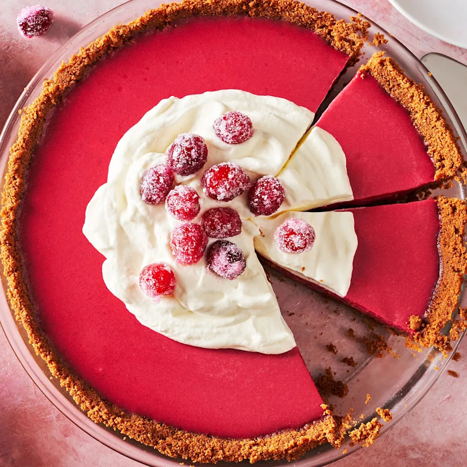 cranberry pie topped with whipped pink and sugared cranberries