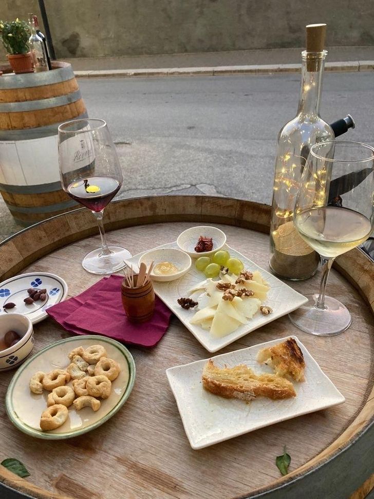 A cheese plate with bread and fruit is served with wine. Experts urge customers to avoid purchasing fake Italian cheese by checking the label and origin. Courtesy of Han Sang-hee