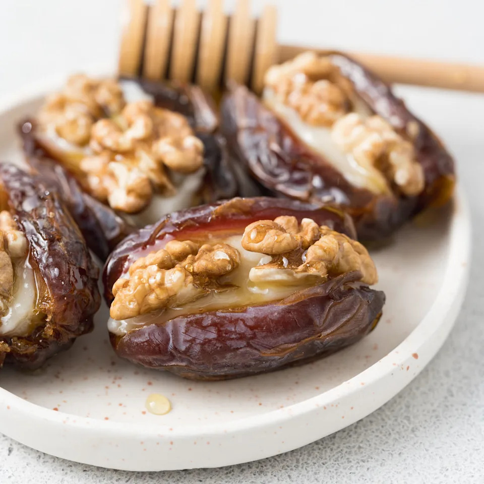 stuffed dates on a plate topped with honey
