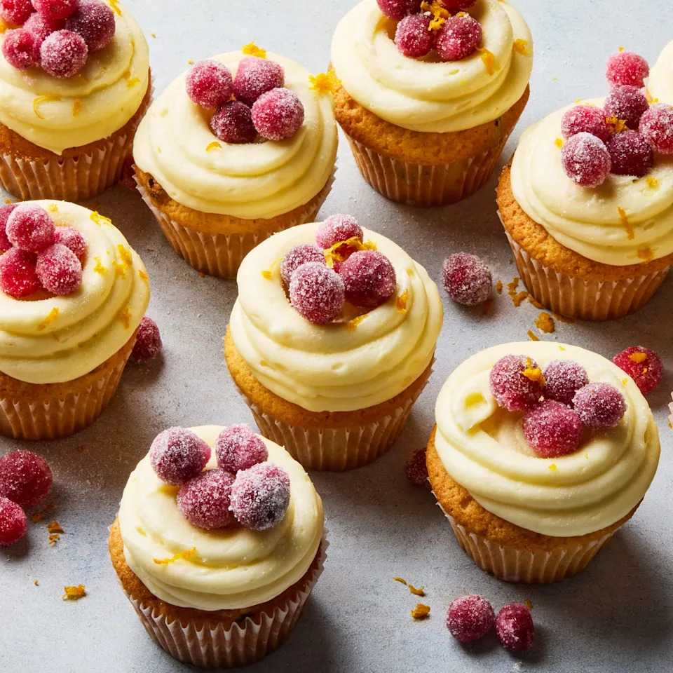 cupcakes topped with icing and sugared cranberries