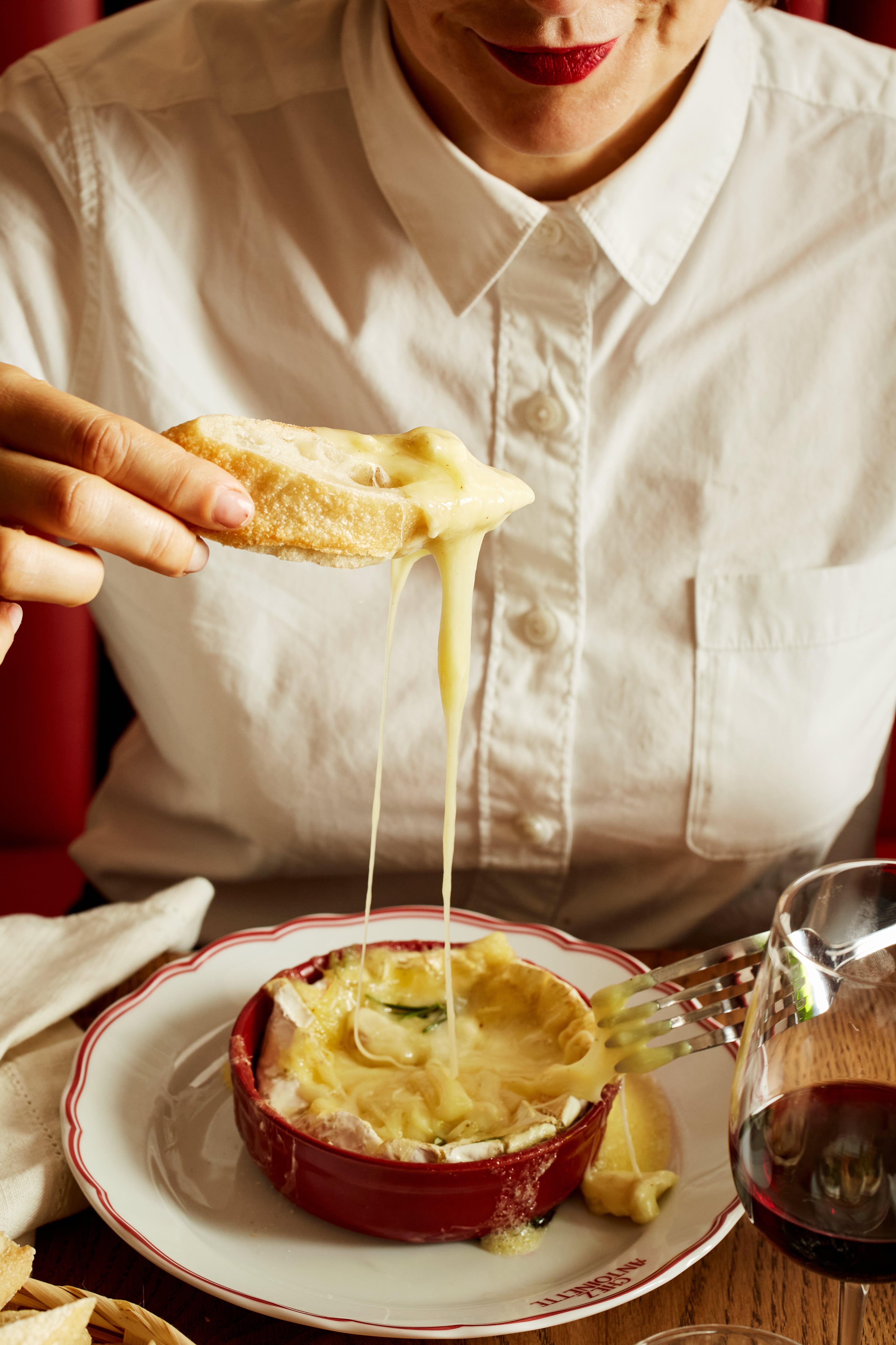 Someone dipping bread in camembert