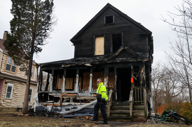 Marcial Rodriguez, CEO of 911 Fire Board-Up and Construction, walks in front of Leandrea and John Hernandez's home that caught fire on Christmas Eve in the 3100 Block of Ezekiel Avenue in Zion, Dec. 26, 2025. All eight people and their pets made it out of the house alive. (Dominic Di Palermo/Chicago Tribune)