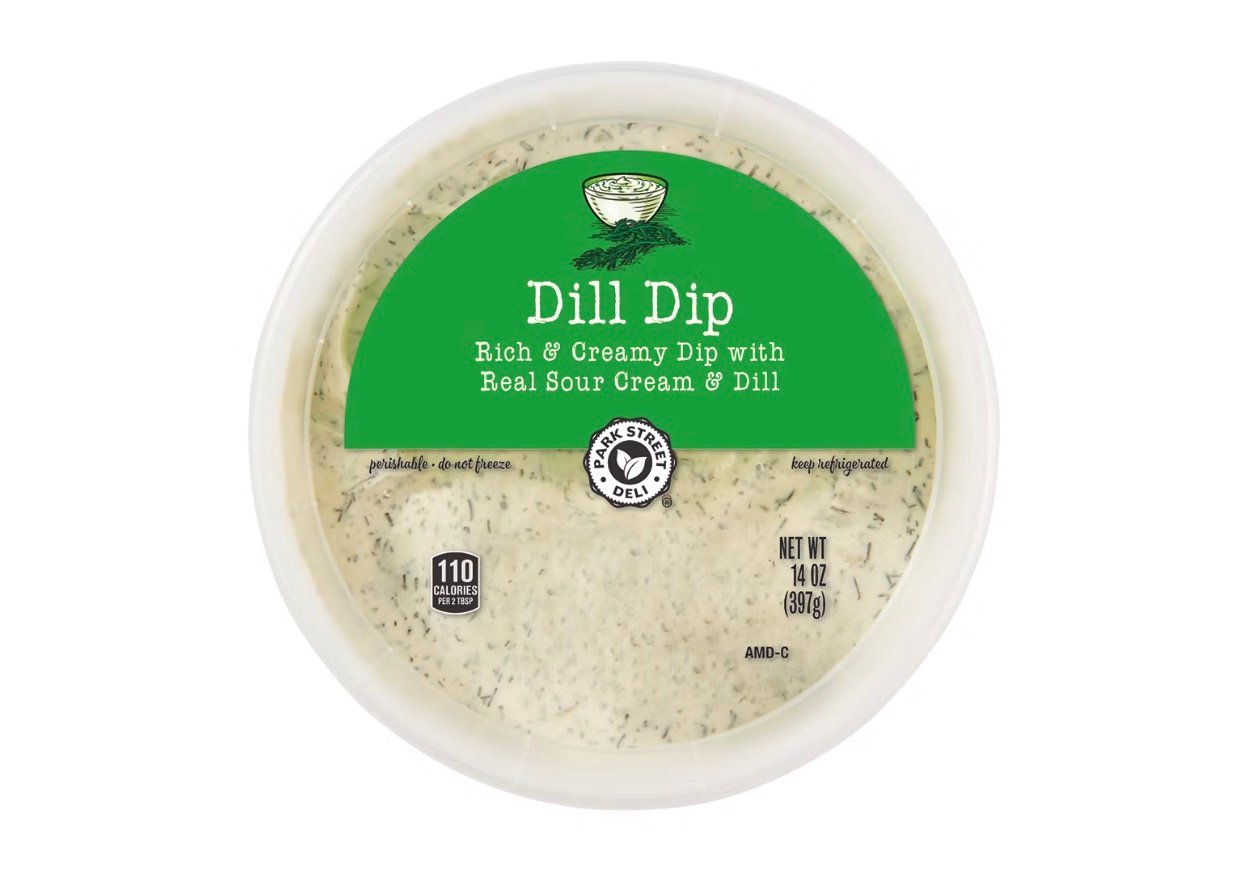 A round plastic container of dill dip. The label reads, "Dill Dip: Rich & Creamy Dip with Real Sour Cream & Dill," and shows the weight as 14 oz (397g). The dip is white with visible green dill flecks.