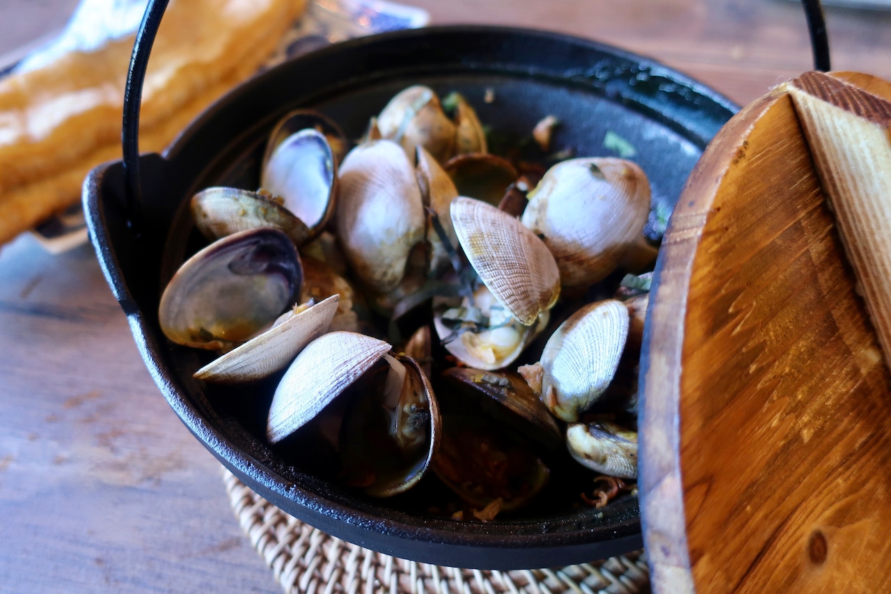 Clams in a broth redolent of caramelized pineapple at The Paper Bridge.