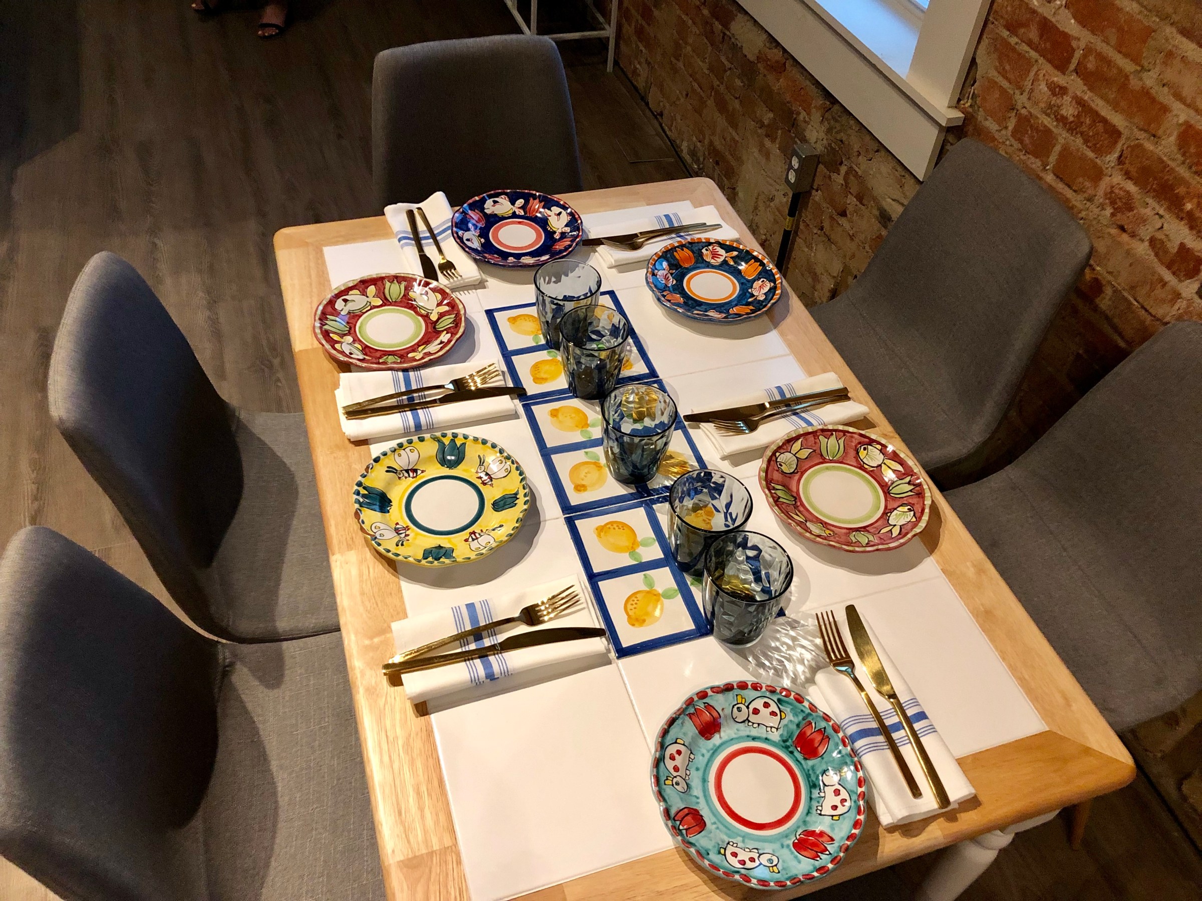 Plates handmade along the Amalfi coastline, splashed with colorful images of octopuses and elephants, line tables and function as circular wall decor.