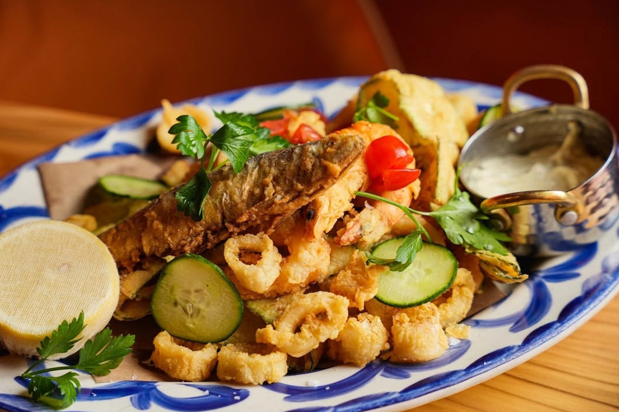 Fried seafood and vegetables on blue white plate