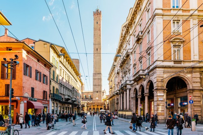 Street in Bologna with the Asinelli tower in the centre in Emilia Romagna, Italy.