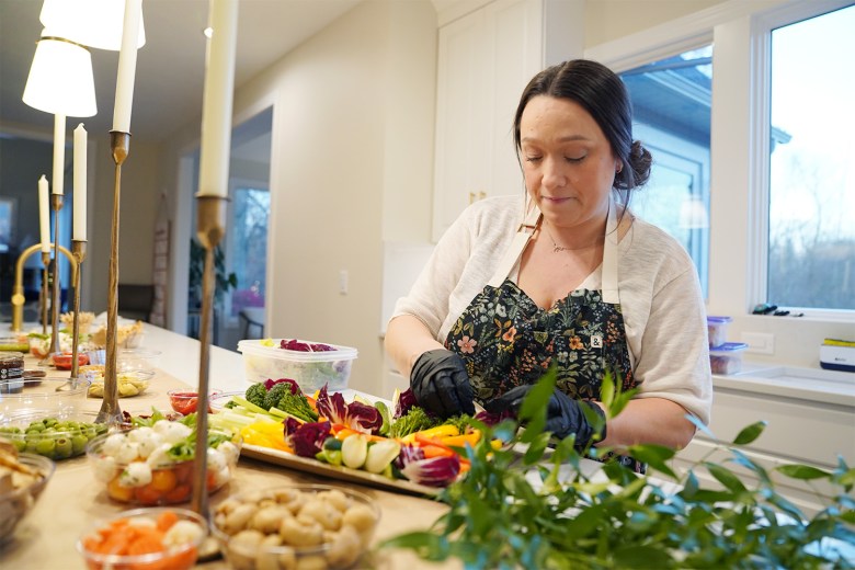 Liz Stannard, owner of Waxed Crescent Grazing Company, prepares a "graze," which typically consists of cheese, charcuterie and other small bites, for a party at a home in Hudson.