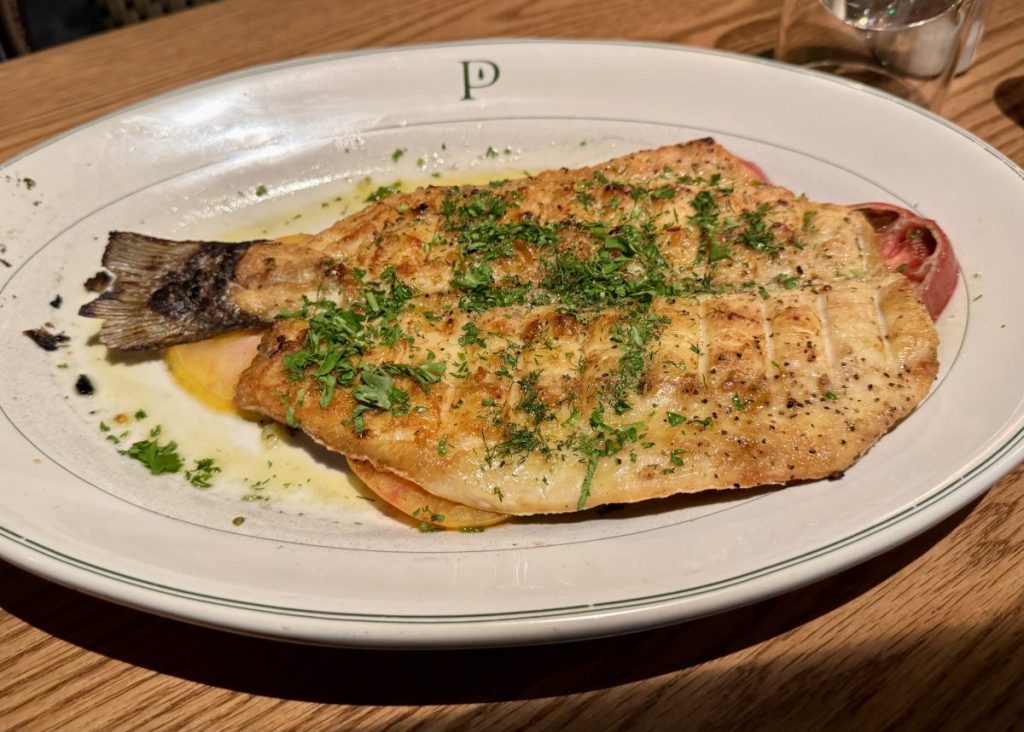 A butterflied fish on a platter.