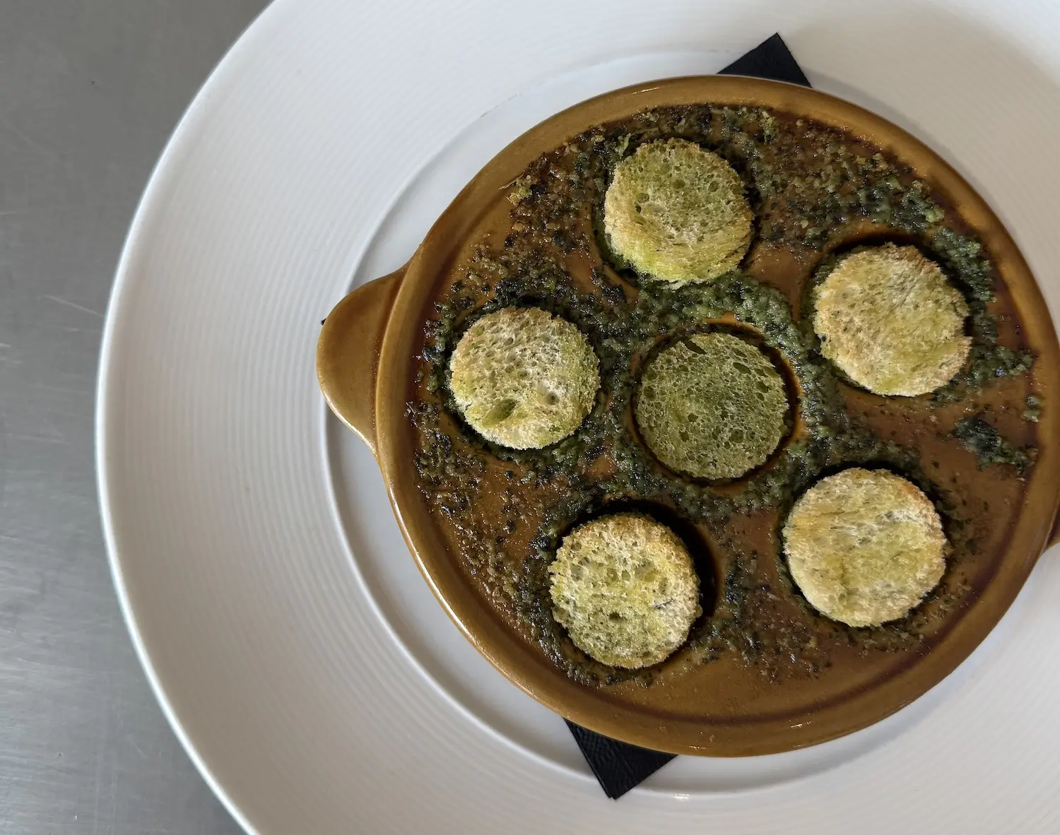 Food from San Diego restaurant Bistro Du Marché in La Jolla featuring their Escargots De Bourgogne, Beurre D’ail & Herbes Potagères