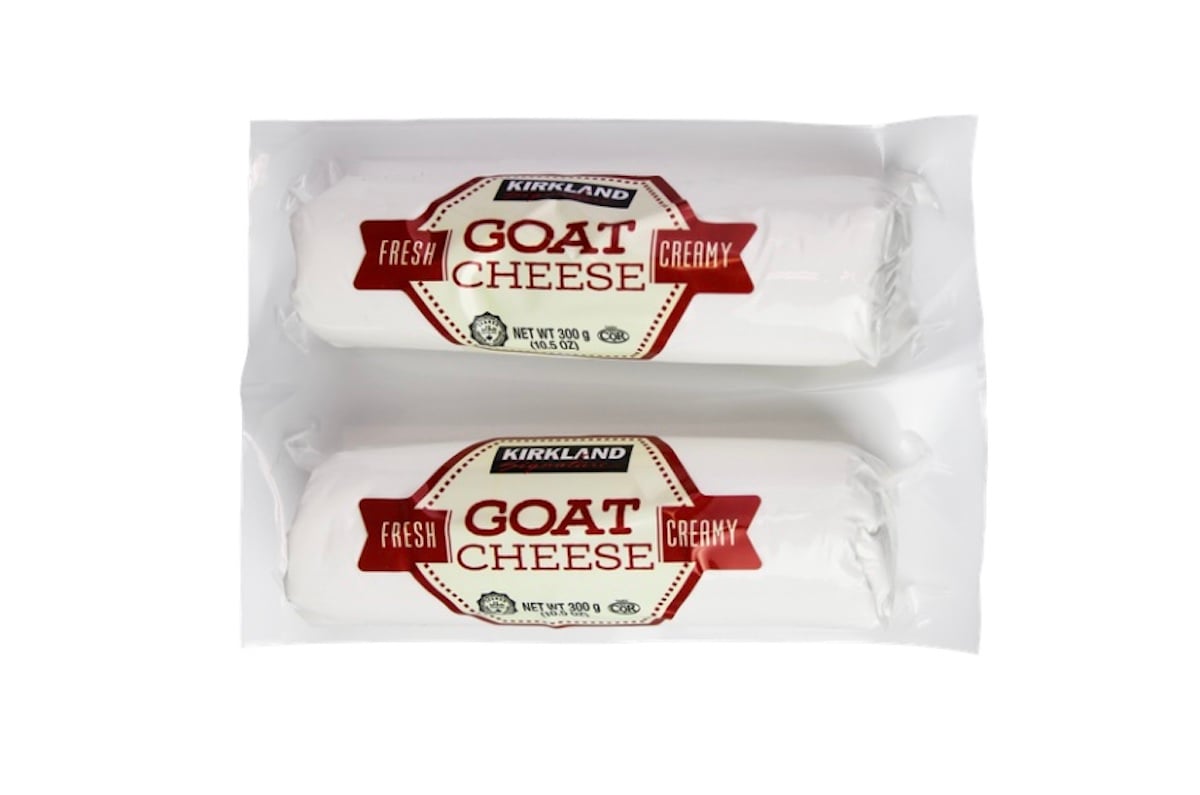 Two logs of Kirkland brand fresh creamy goat cheese in white packaging with red and brown labels, placed side by side in a clear plastic wrap.