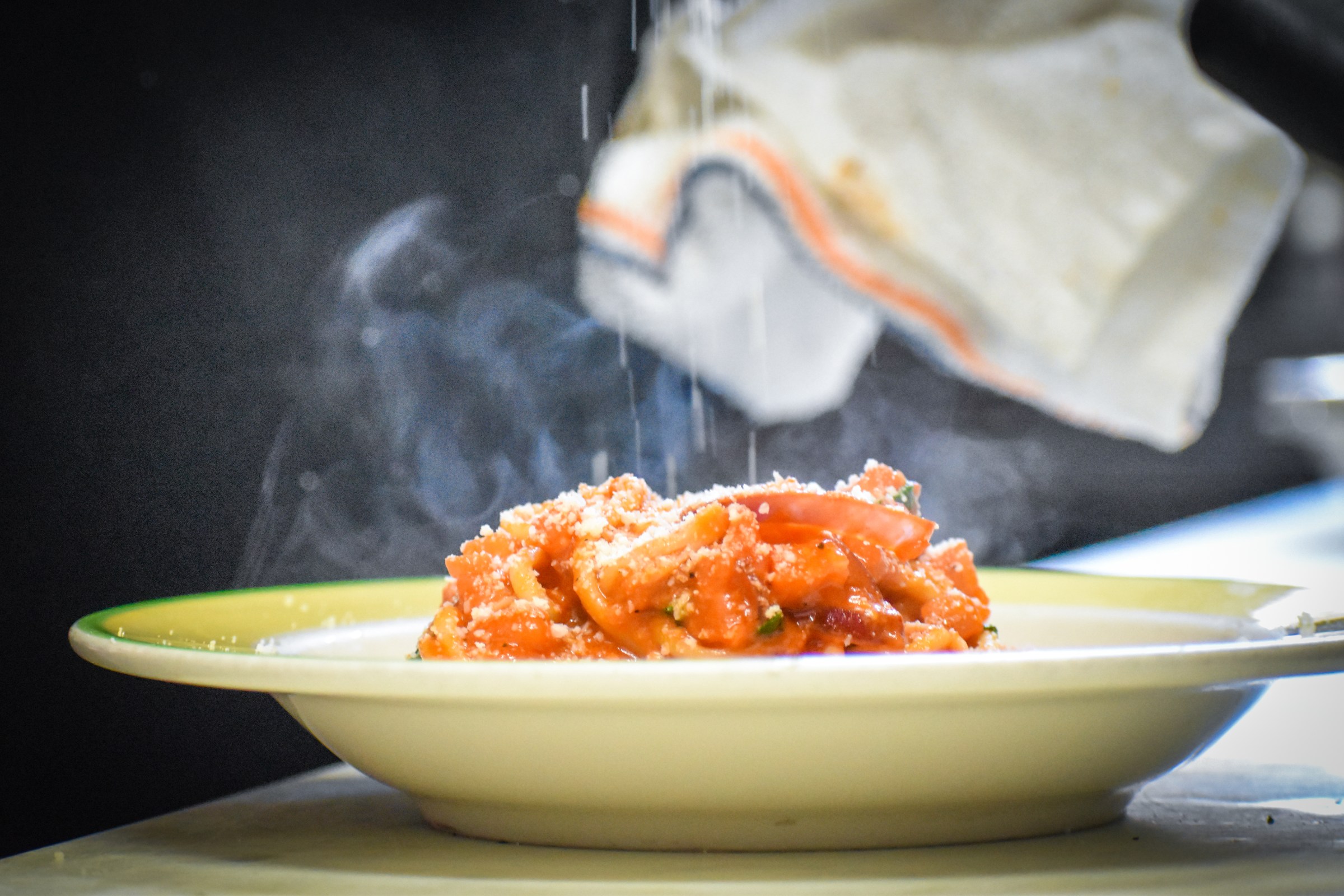 Showering a bowl of amatriciana with Parmesan at La Parolaccia.