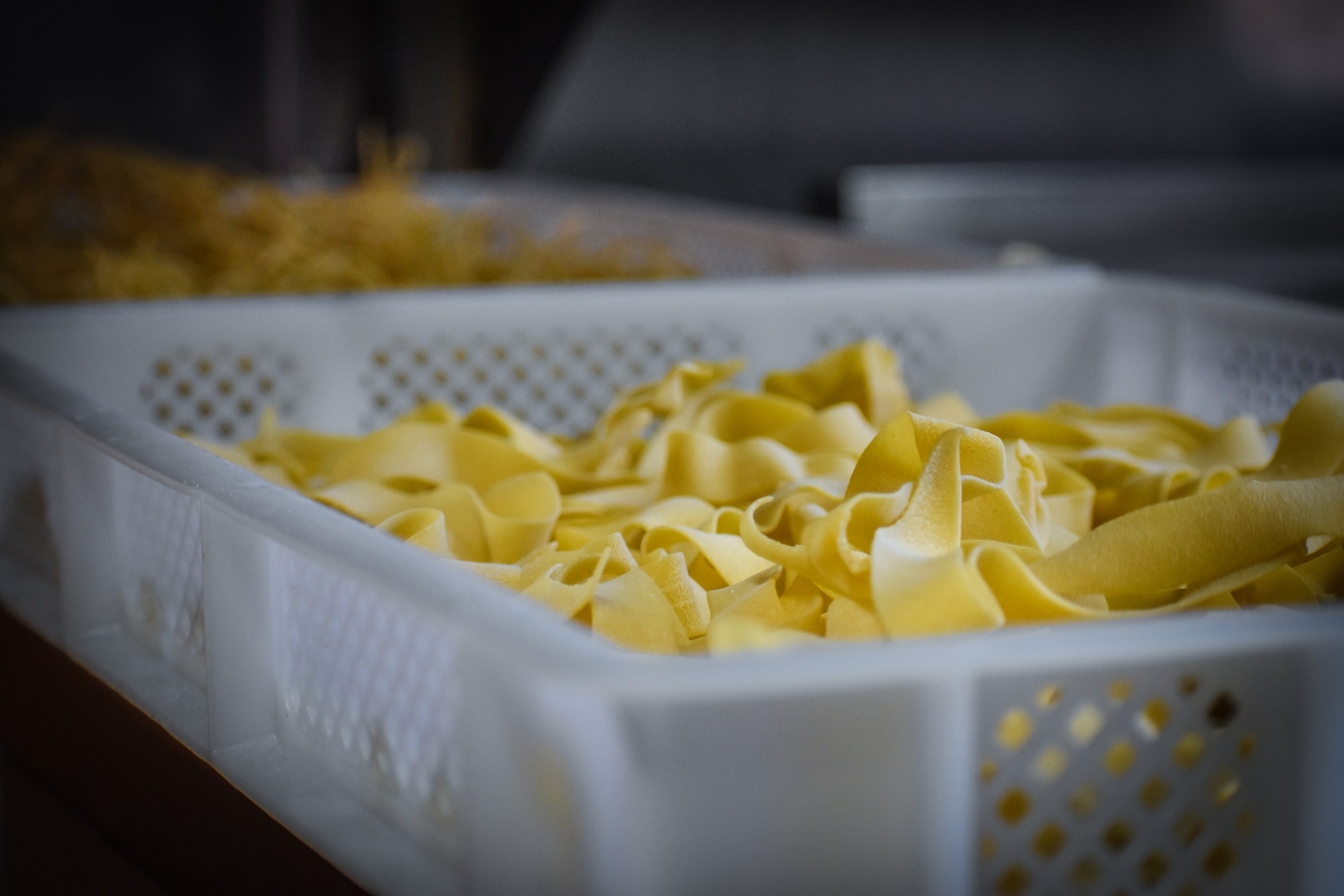 Fresh house-made tagliatelle in a white bin at La Parolaccia.