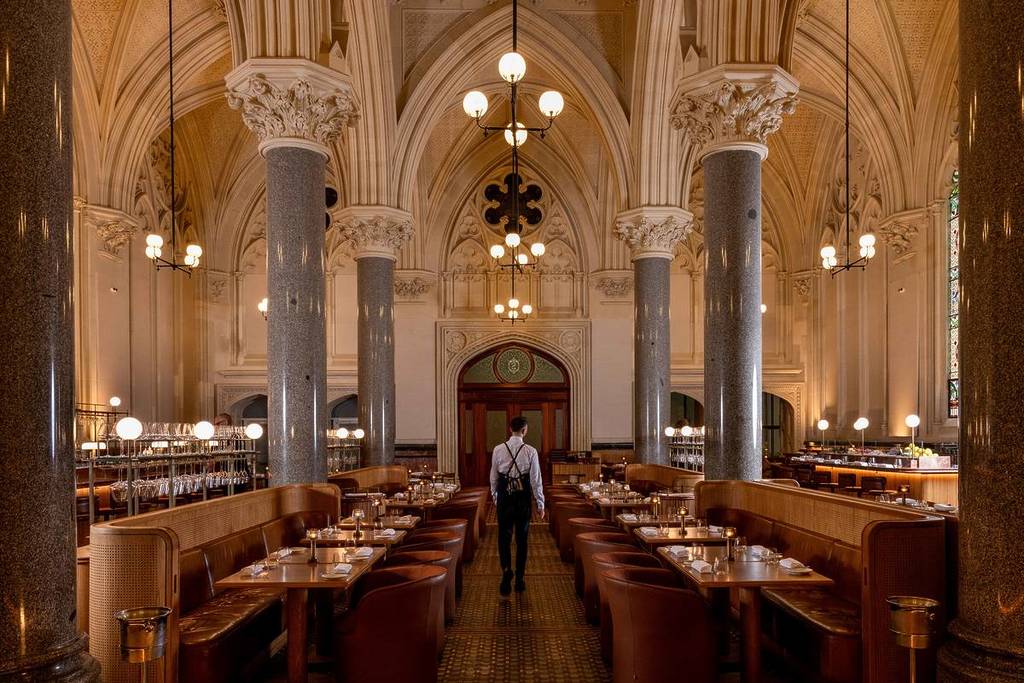 waiter walking through the grand space of Reine and La Rue