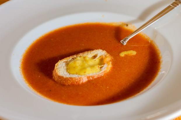 A toast topped with rouille, a garlicky red pepper mayonnaise, served over soupe de poissons, a French seafood dish prepared by Georgeanne Brennan at her home in Winters, Calif., on Friday, Nov. 21, 2025. (Ray Chavez/Bay Area News Group)