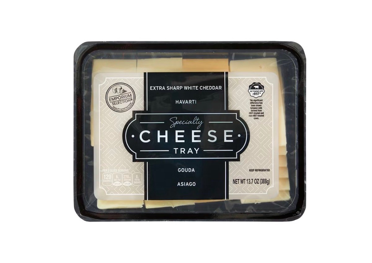 A plastic-wrapped cheese tray labeled "Speciality Cheese Tray" containing extra sharp white cheddar, havarti, gouda, and asiago cheeses. The package is rectangular and shows cheese slices inside.