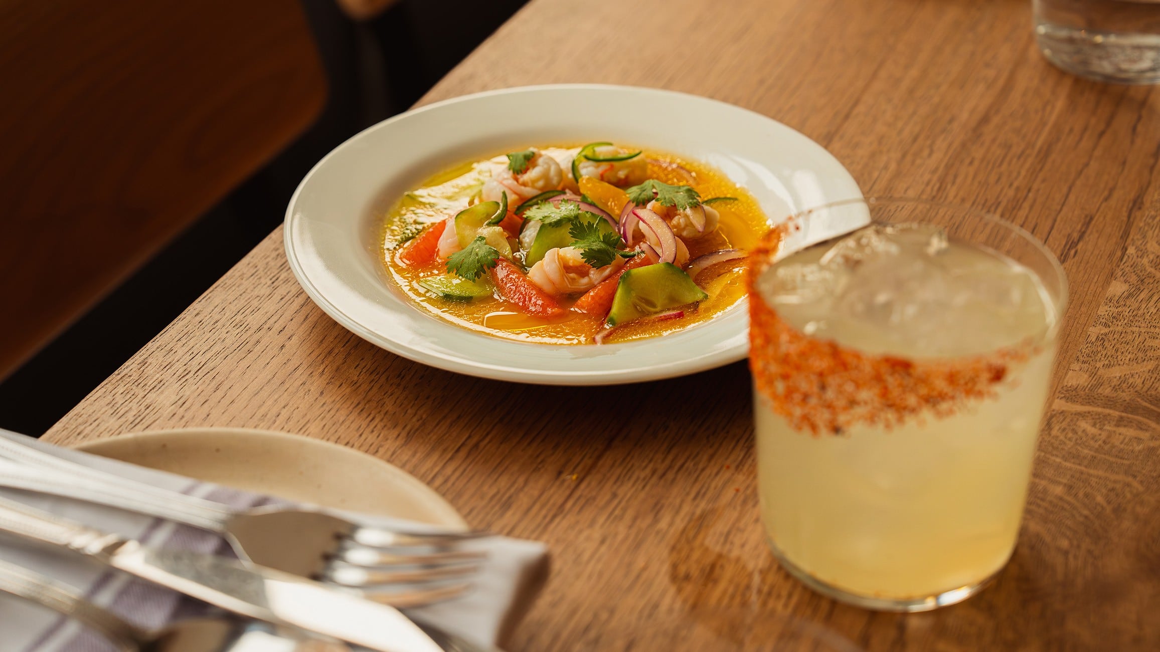 Mexican food plate on table next to spicy Margarita
