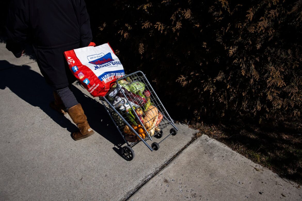 A woman walked home with her groceries from the La Colaborativa's biweekly food distribution in Chelsea in 2023.
