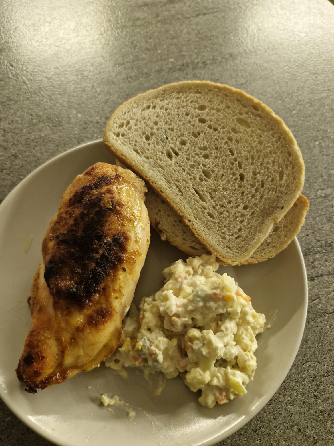 A chicken breast with bread and vegetable salad,simple,but good