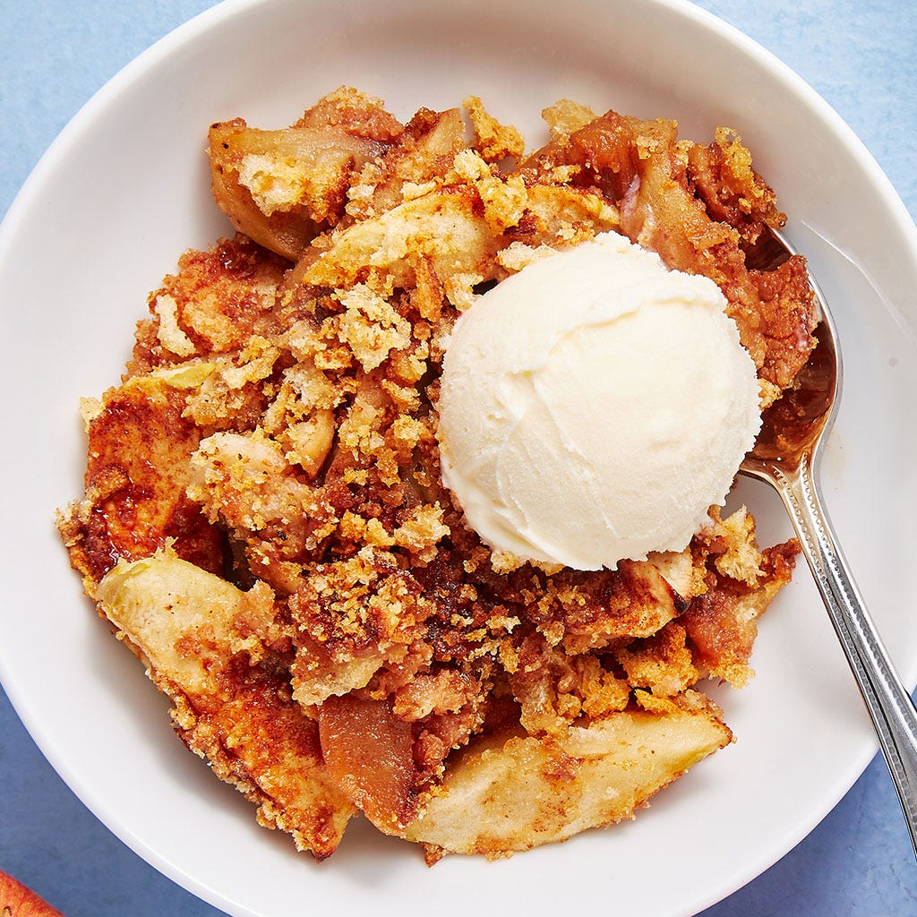apple brown betty in a white baking dish and a white bowl with a scoop of ice cream