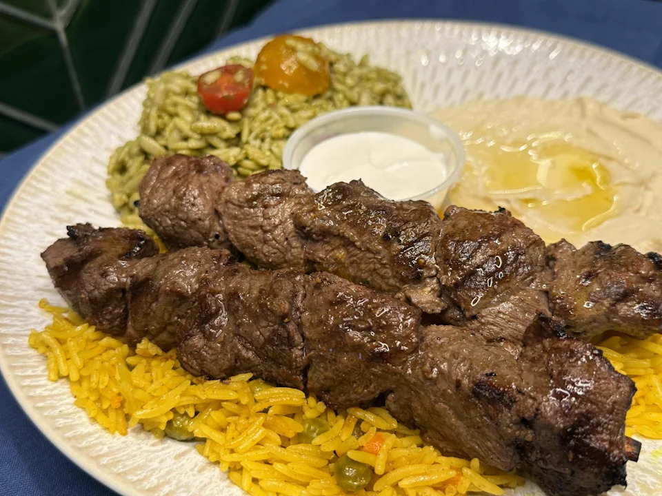 A steak kebab platter from Urban Olive Mediterranean, served with rice, hummus and pesto orzo.