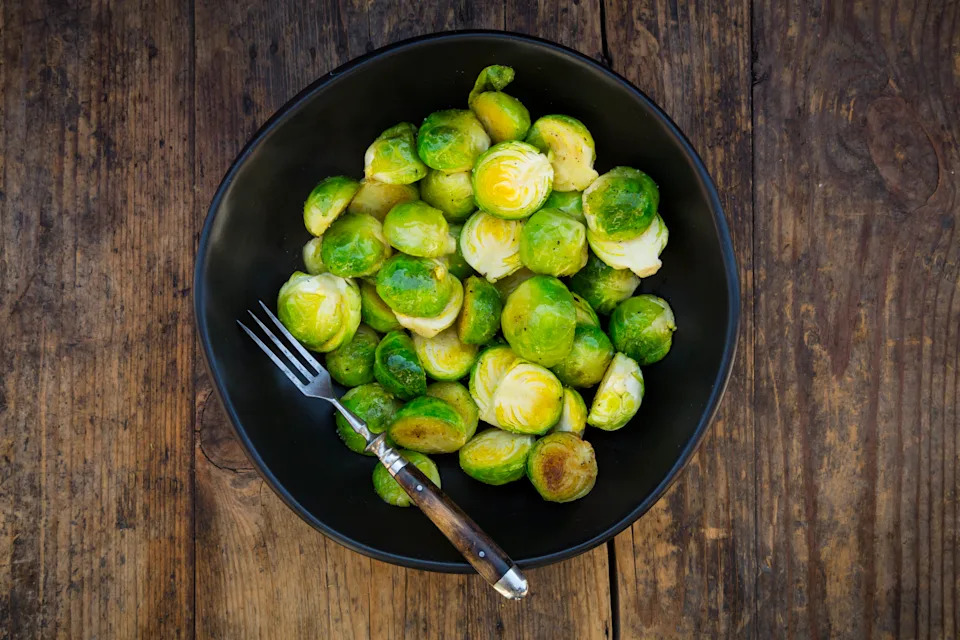 Bowl of fried Brussels sprouts on dark wood