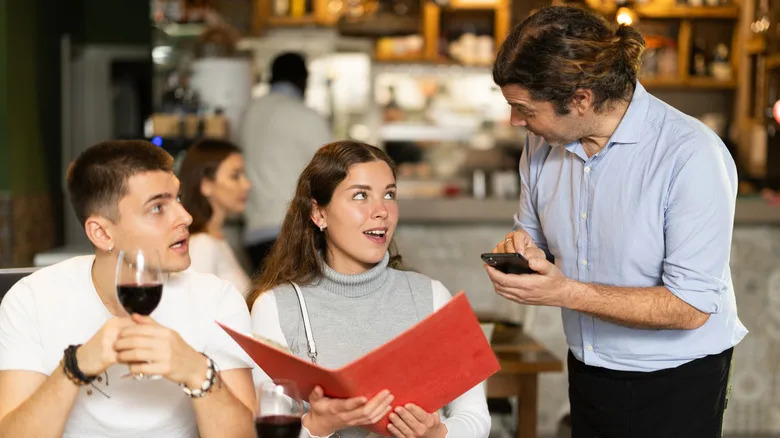 Dining couple talking to a waiter