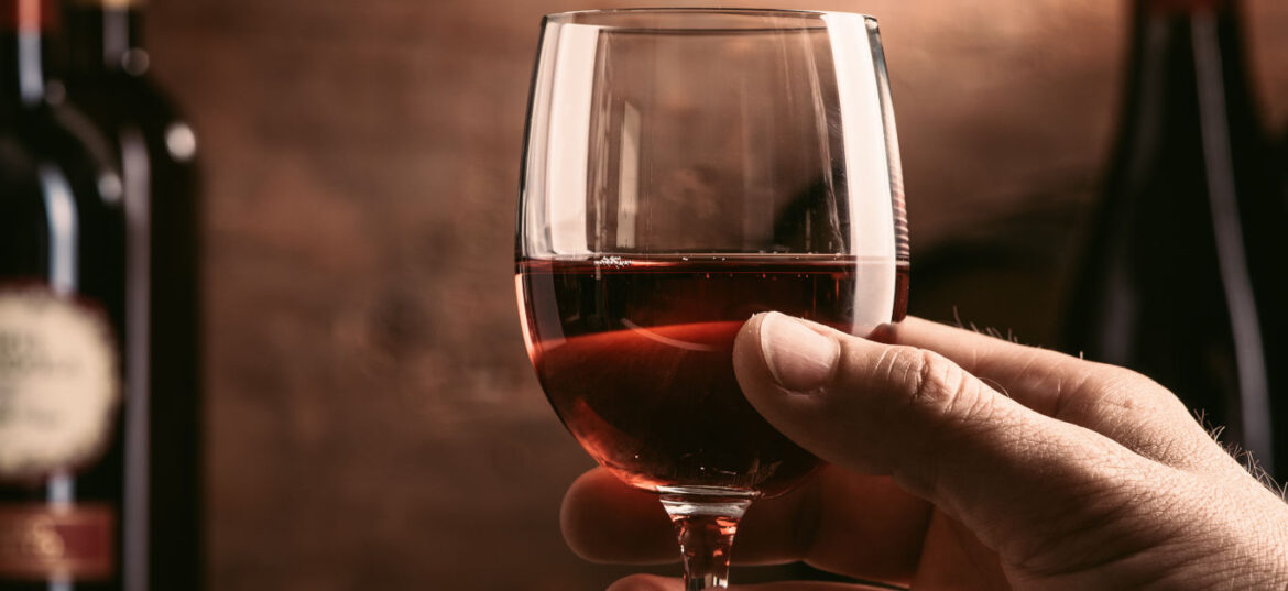 9 superb alternatives to your favourite French wines Wine tasting experience in the rustic cellar and wine bar: sommelier holding a glass of delicious red wine and excellent wine bottles collection on the background